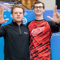 Two alumni pose for a picture at the Detroit Red Wings GVSU Night